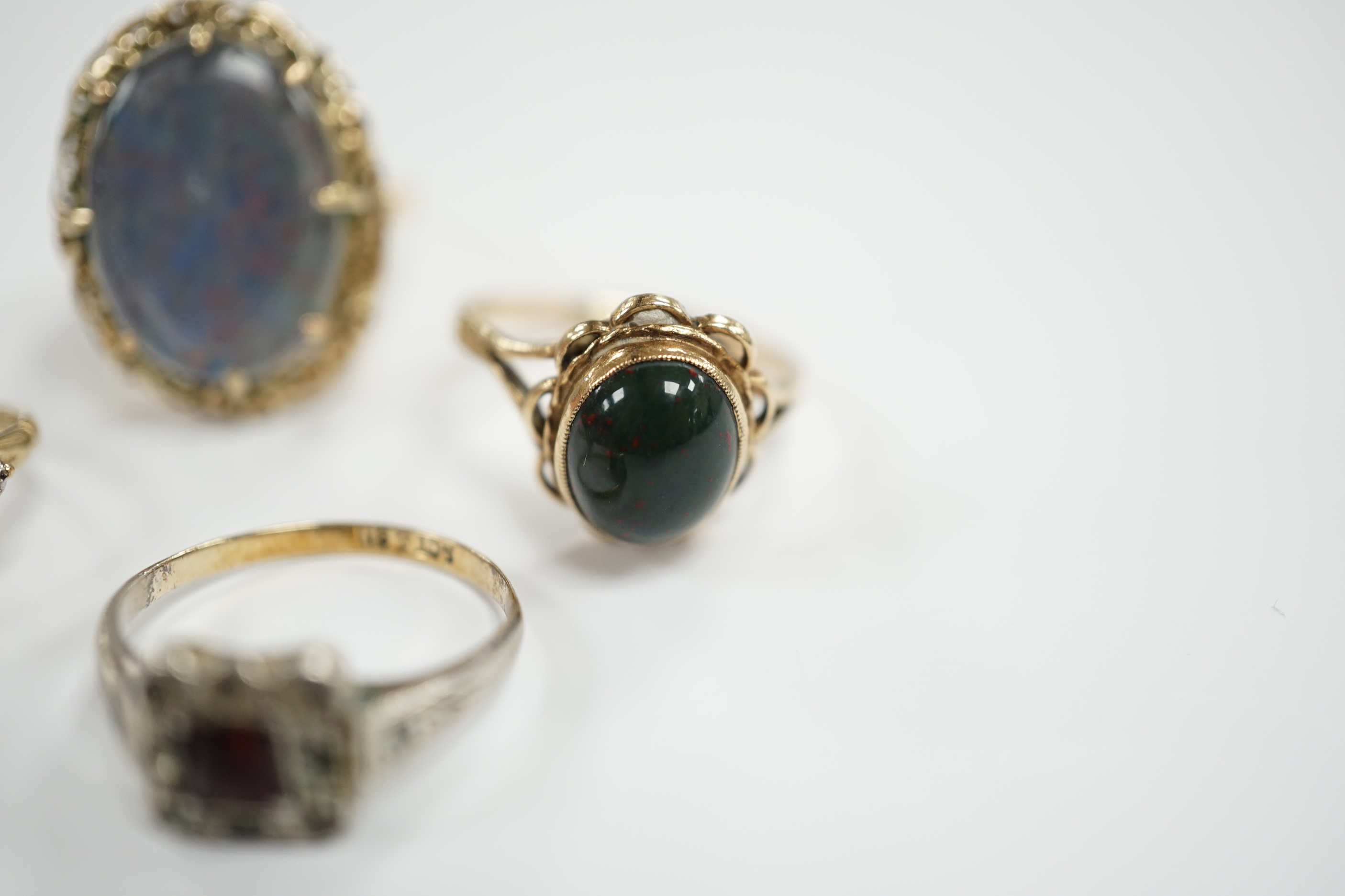 Two 9ct and gem set rings including cabochon bloodstone, a 14k and opal? doublet set ring and one other ring.